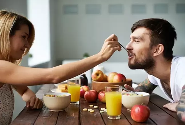 A woman feeds a man nuts to increase potency